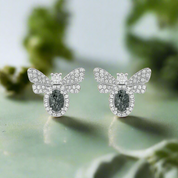 Butterfly-shaped earrings with gemstones on a white background