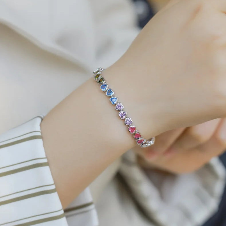 Close-up of a hand wearing a colorful beaded bracelet with a blurred background