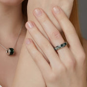 Close-up of a hand wearing a ring with a blurred background