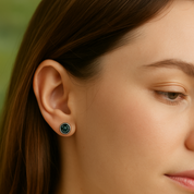 Close-up of a woman wearing a green earring with a blurred background