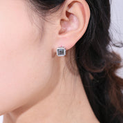 Close-up of an ear wearing a diamond stud earring with a blurred background