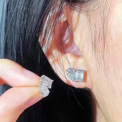 Close-up of diamond earrings being worn on an ear