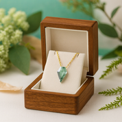 Green gemstone necklace in a wooden box with a natural background
