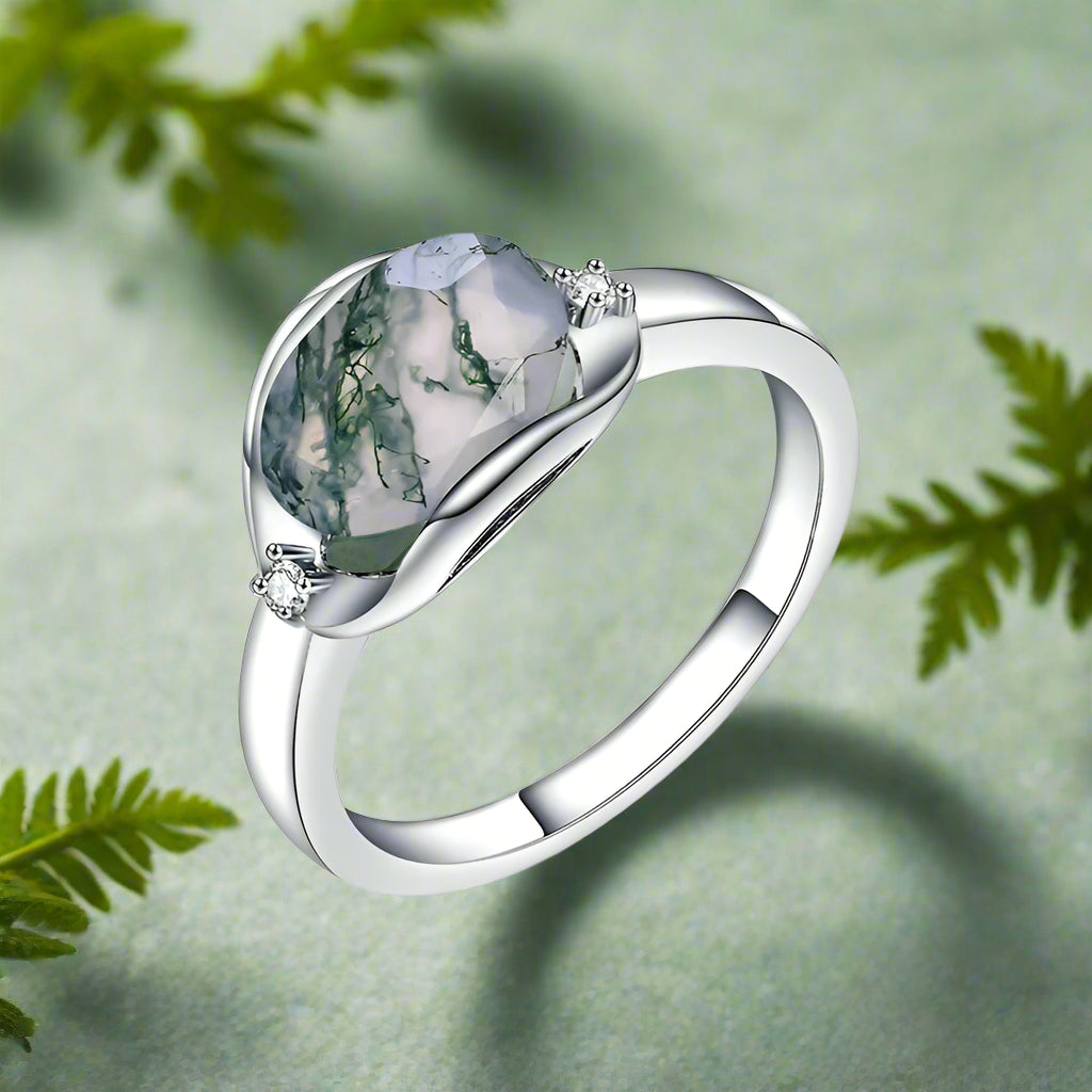 Silver ring with a green gemstone on a white background