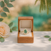 Emerald ring in a wooden box with a blurred natural background