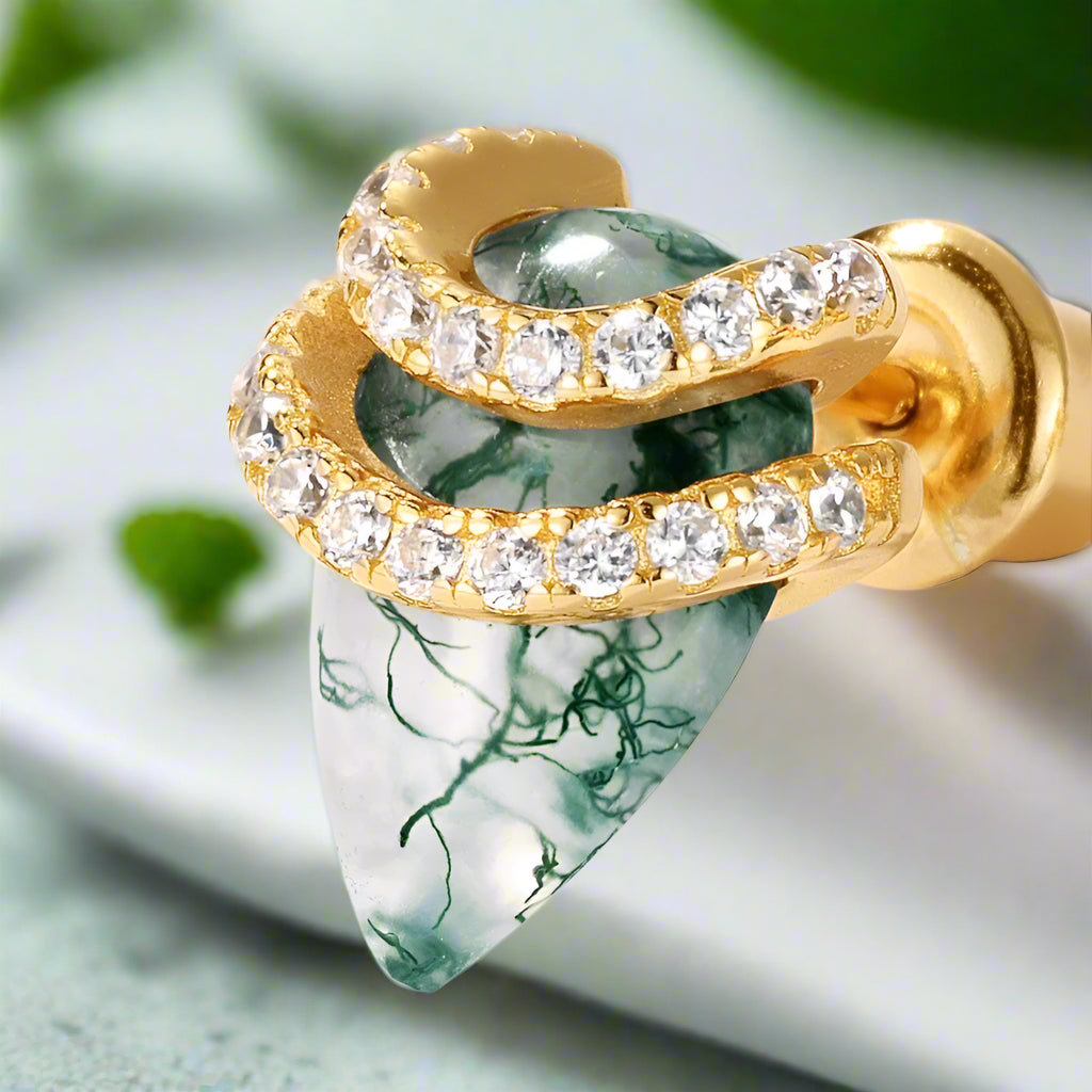 Gold and green stone earring with clear gemstones on a white background