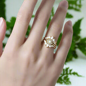 Gold ring with a floral design on a hand