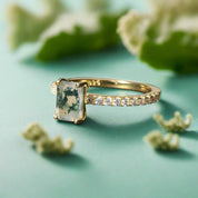 Gold ring with a green gemstone on a dark surface