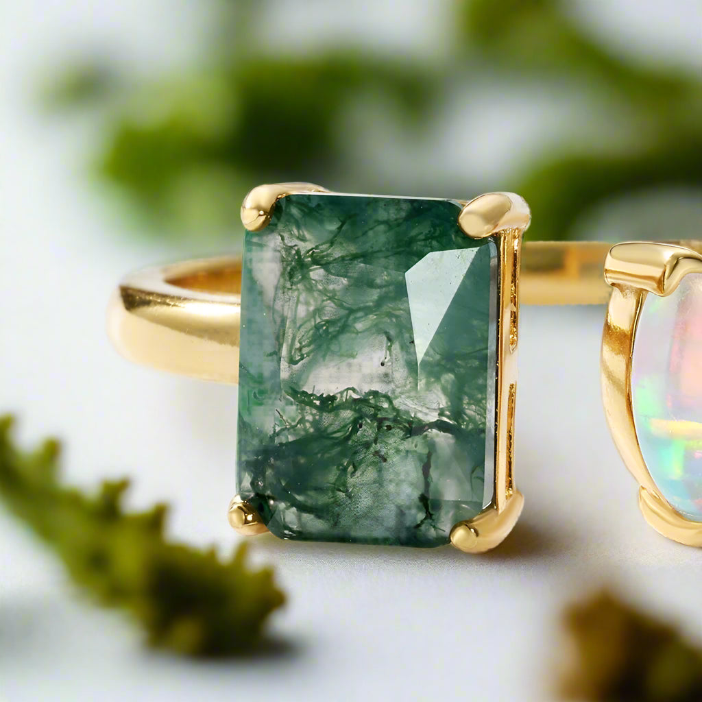 Gold ring with a green gemstone on a white background