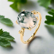 Gold ring with a green stone on a white background