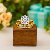 Gold ring with a large diamond on a wooden box with a blurred floral and gift box background