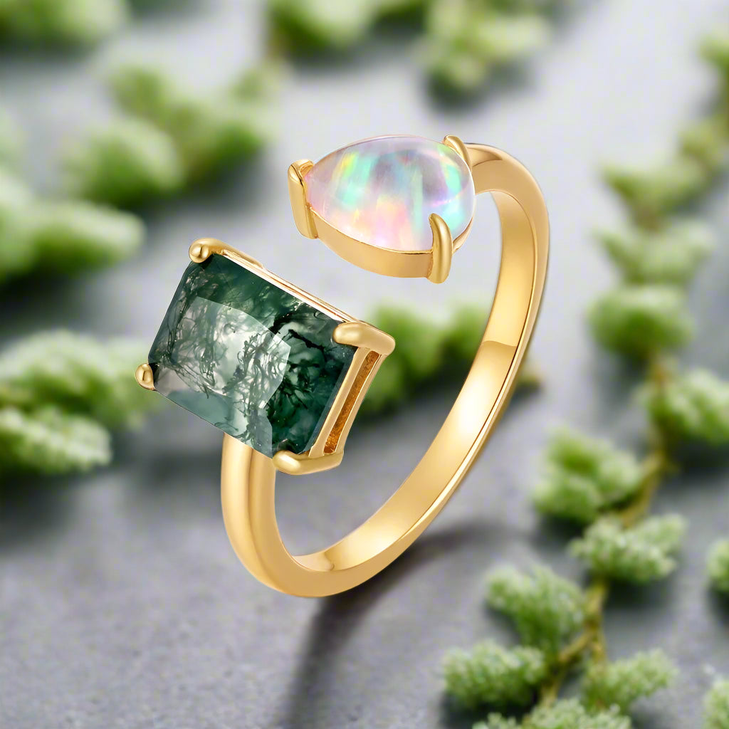 Gold ring with green gemstone and opal on a white background