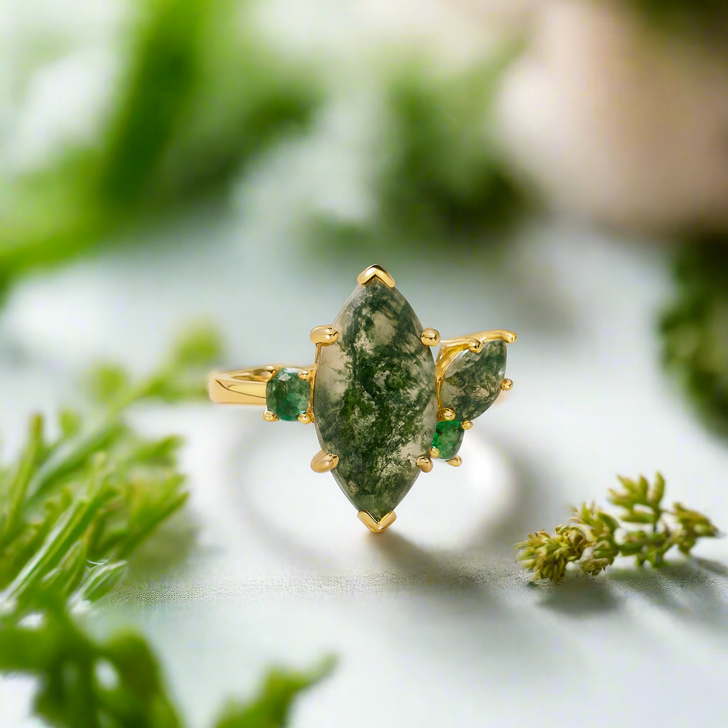 Gold ring with green gemstones on a natural background