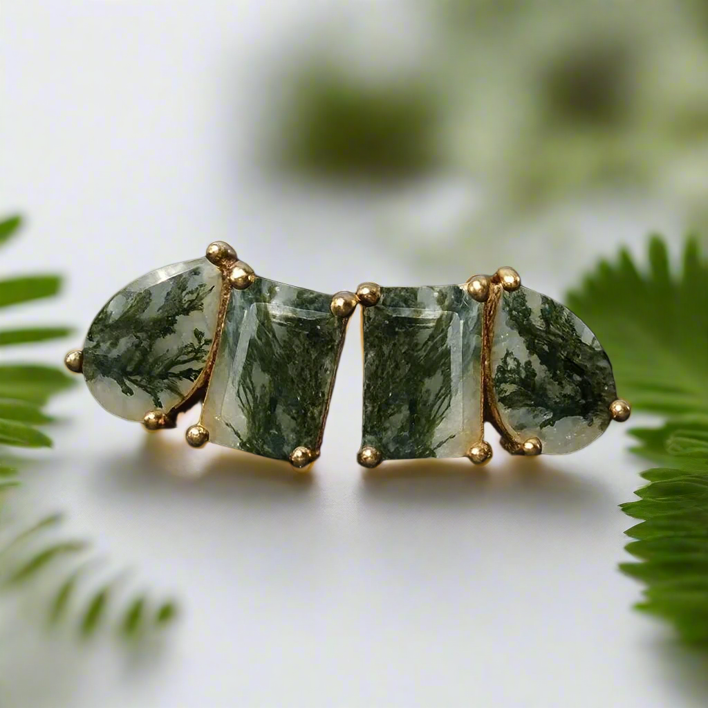Green stone hair clip with gold accents on a textured black surface