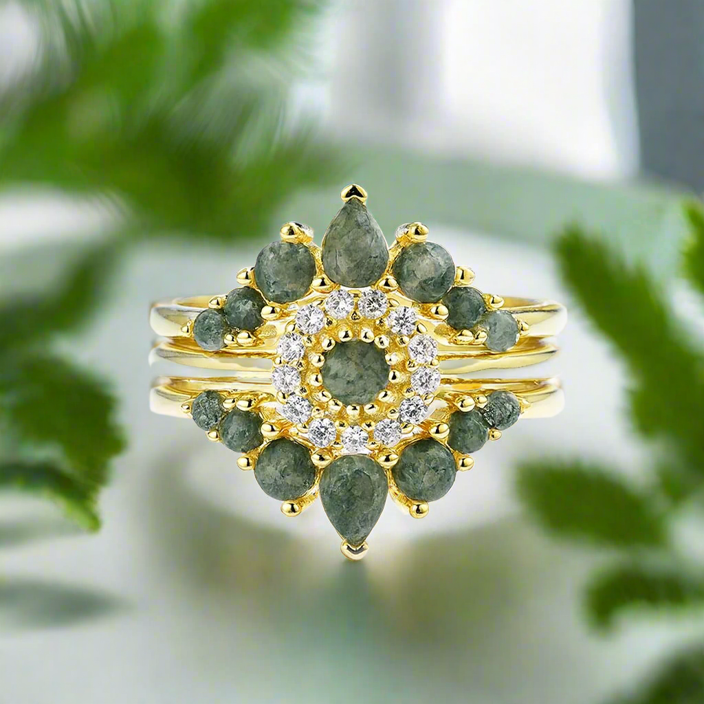 Luxury jewelry ring with green gemstones and gold accents on a white background