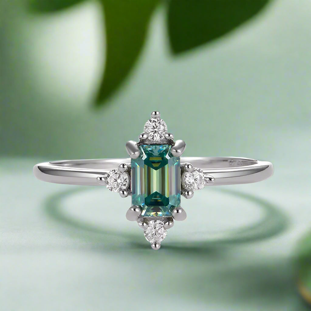 Luxury ring with green gemstone and diamonds on a white background