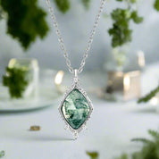 Necklace with a green gemstone pendant on a white background