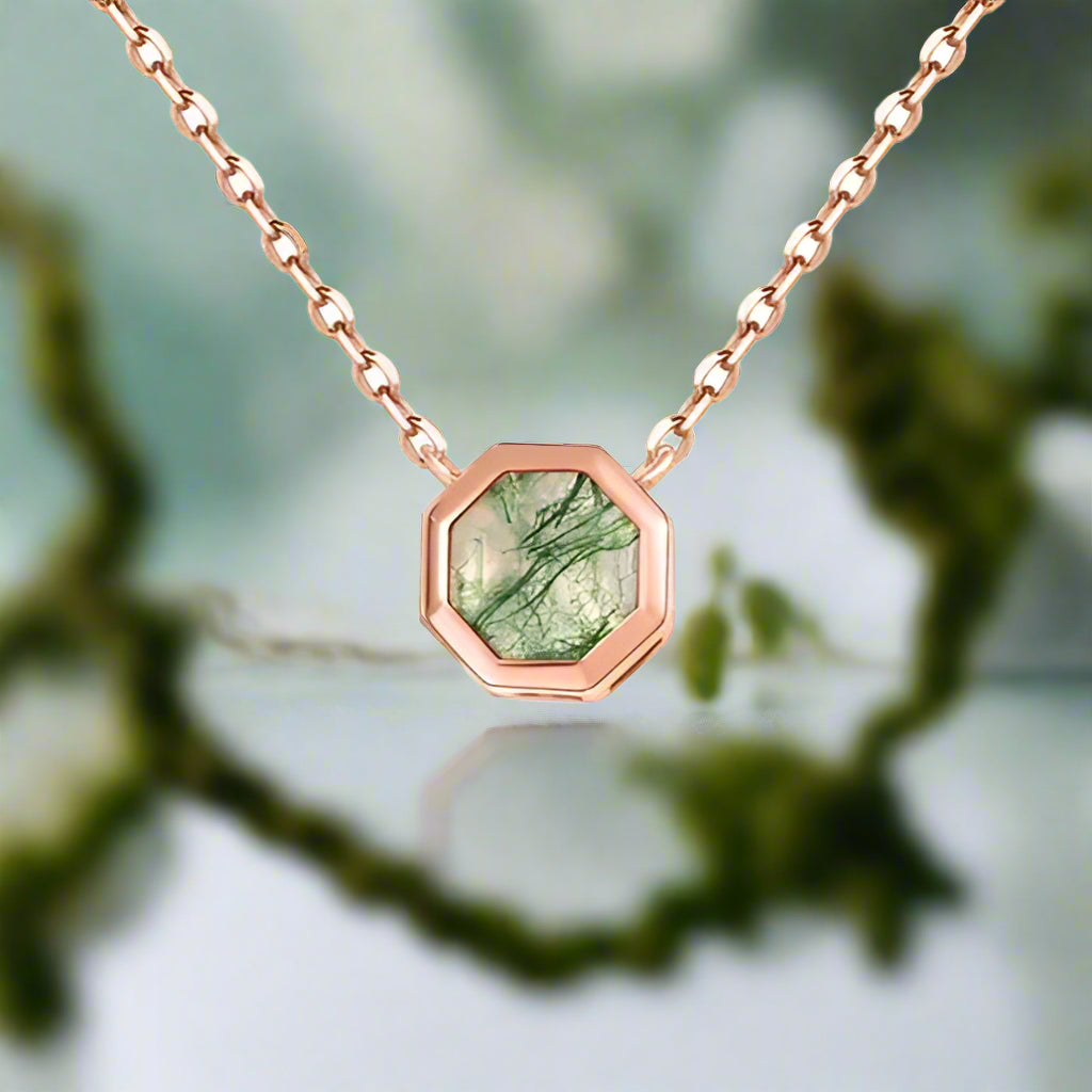 Necklace with a green gemstone pendant on a white background