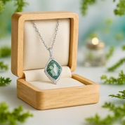 Necklace with a green pendant in a wooden box on a natural background