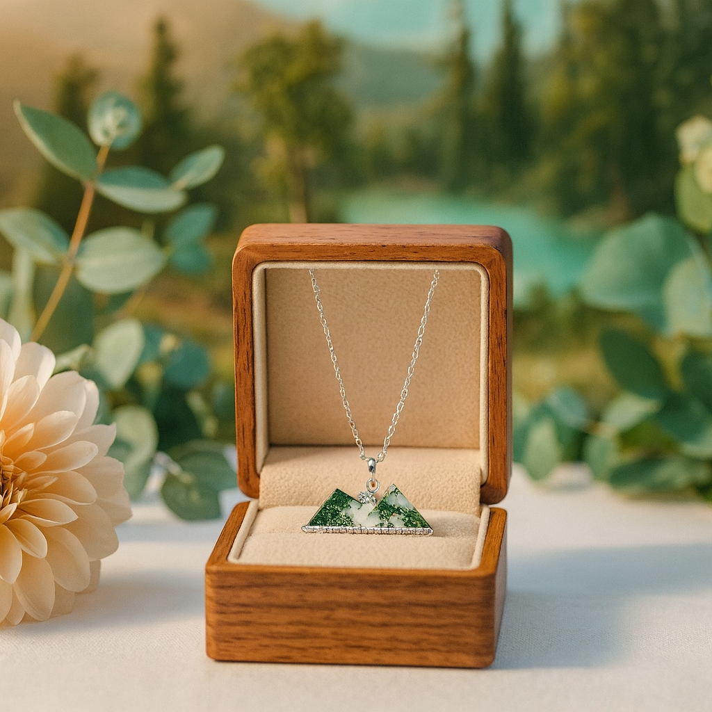 Necklace with a mountain pendant in an open wooden box against a natural background
