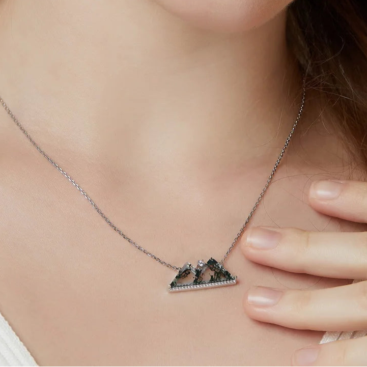 Necklace with a triangular pendant worn by a person