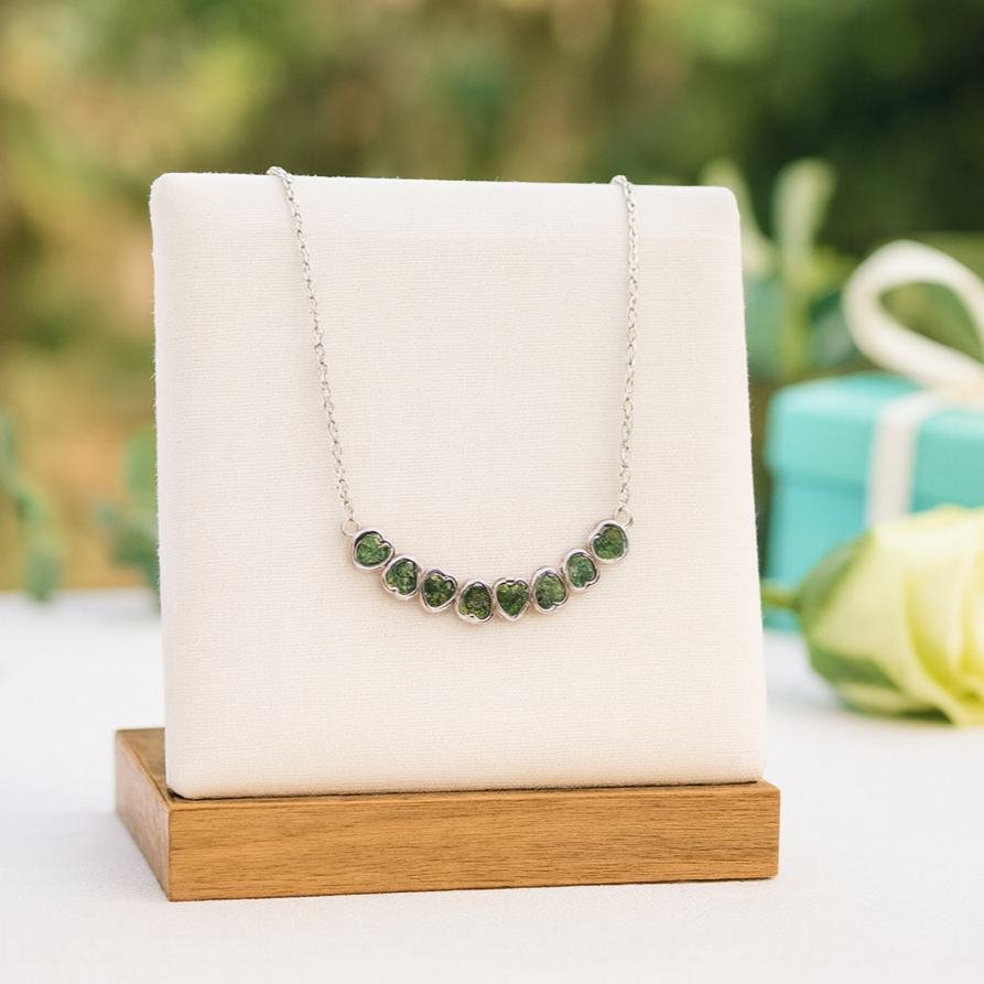 Necklace with green stones on a display stand with a blurred natural background