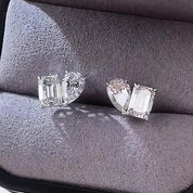 Pair of diamond earrings on a gray cushion in a jewelry box