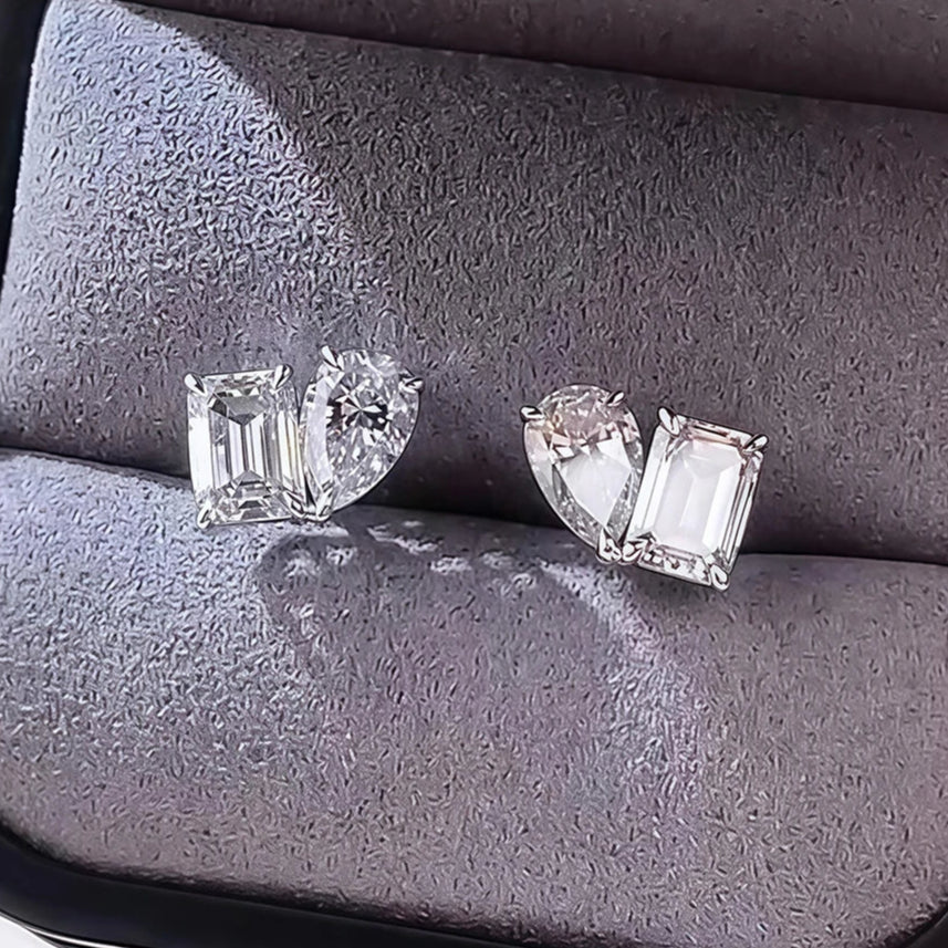 Pair of diamond earrings on a gray cushion in a jewelry box