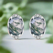 Pair of earrings with green marbled stones on a white background