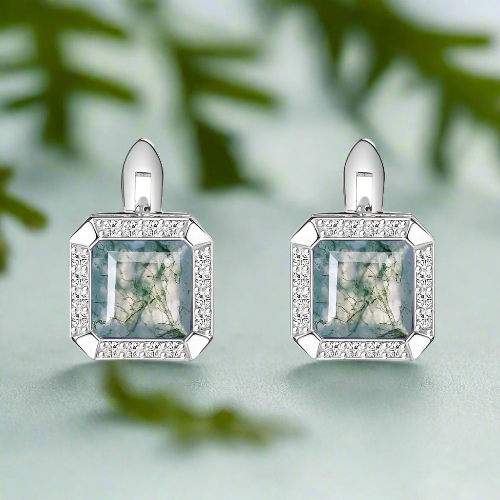 Pair of earrings with square gemstones and diamond accents on a white background