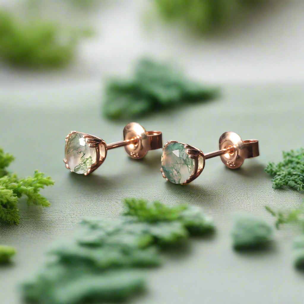 Pair of gemstone stud earrings on a dark surface