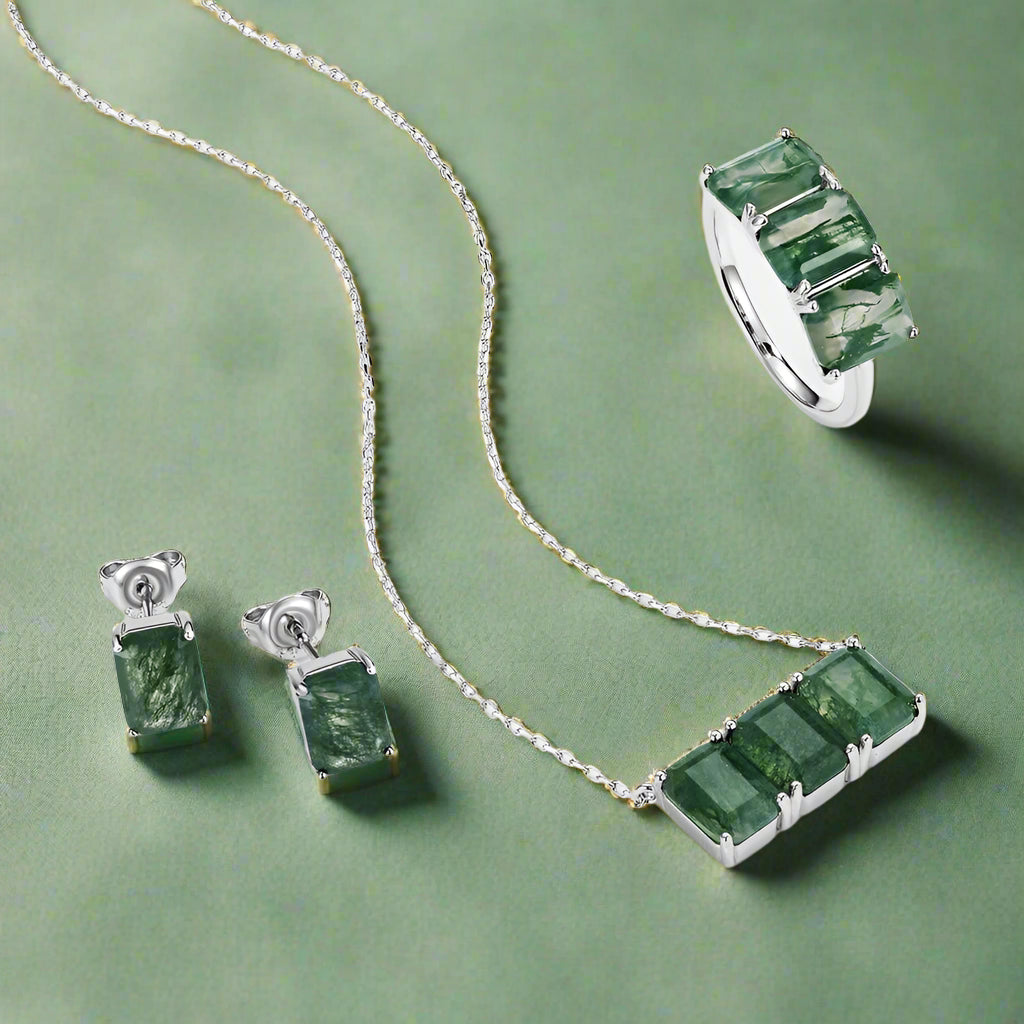 Jewelry set with emerald green stones on a green background