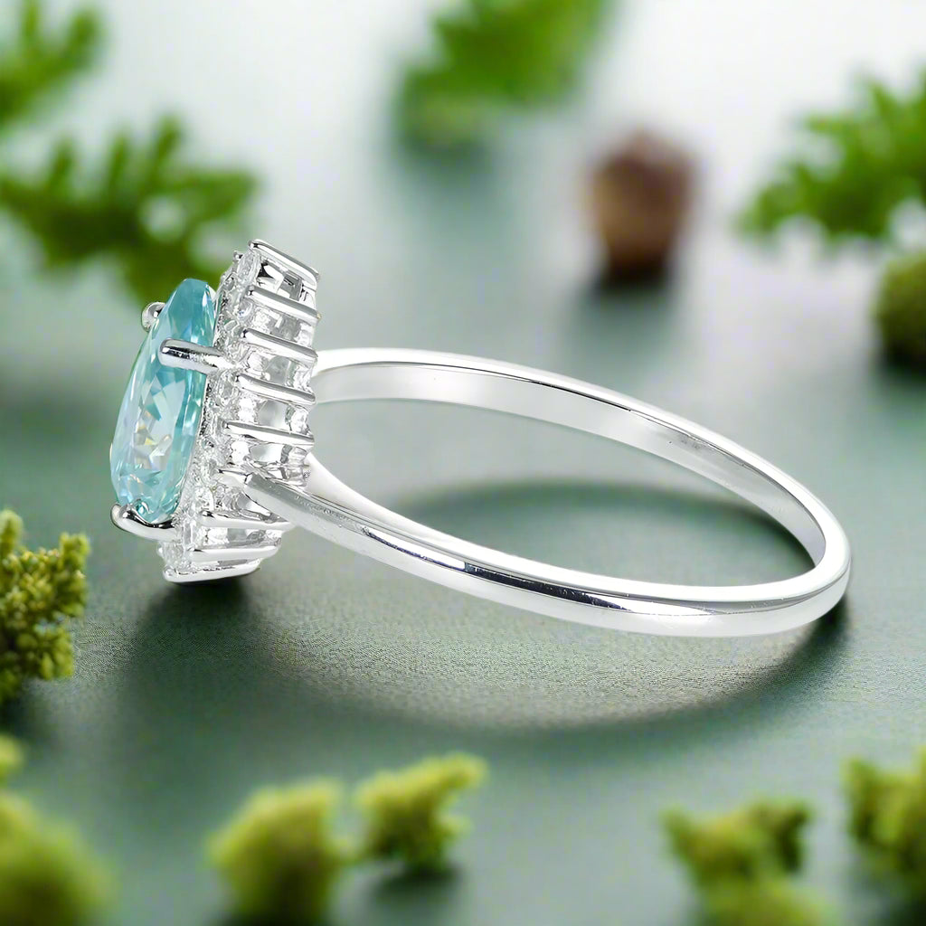 Ring with a blue gemstone and diamond accents on a white background