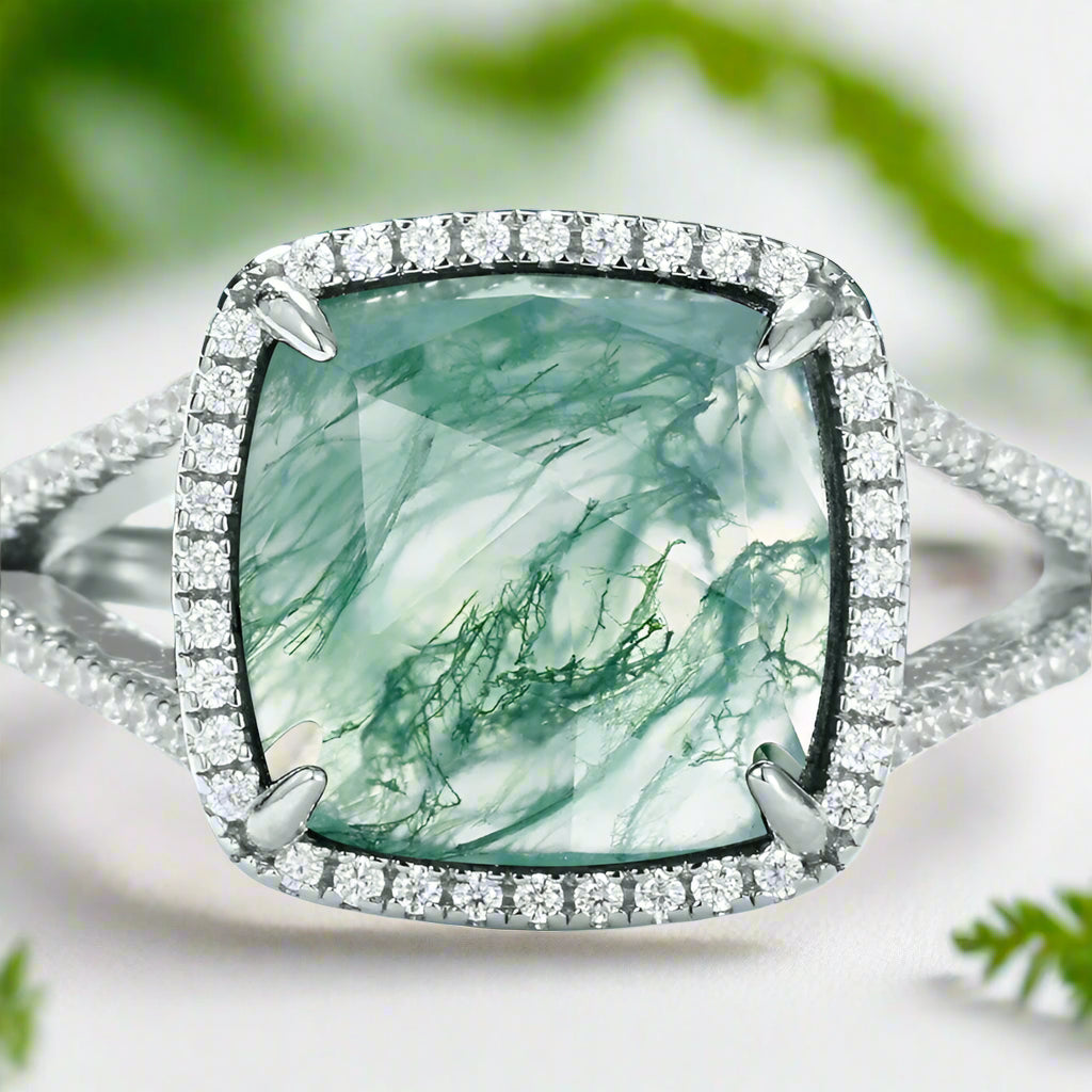 Ring with a green gemstone and diamond-studded band on a light blue background
