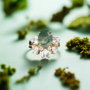 Ring with a green gemstone and diamond accents on a dark background