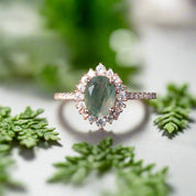 Ring with a green gemstone and diamond accents on a dark surface