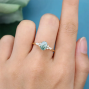 Ring with a green gemstone on a finger against a blue background