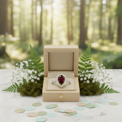 Ring with a red gemstone in a wooden box on a table with a forest background