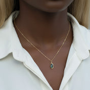 Necklace with a pendant on a mannequin wearing a white coat