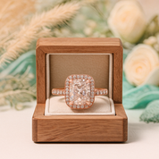 Rose gold diamond ring in a wooden box with a floral background