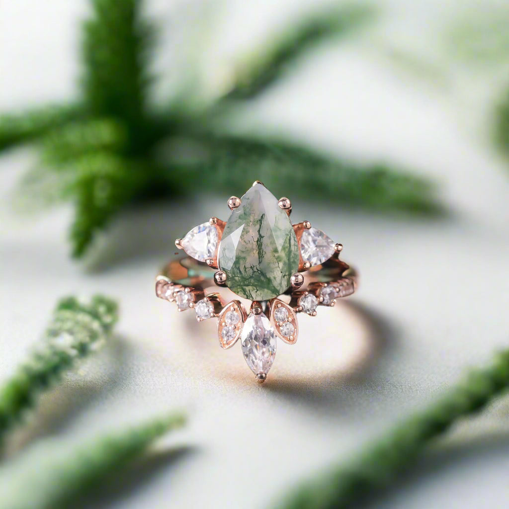 Rose gold ring with a green gemstone and smaller diamonds on a dark background