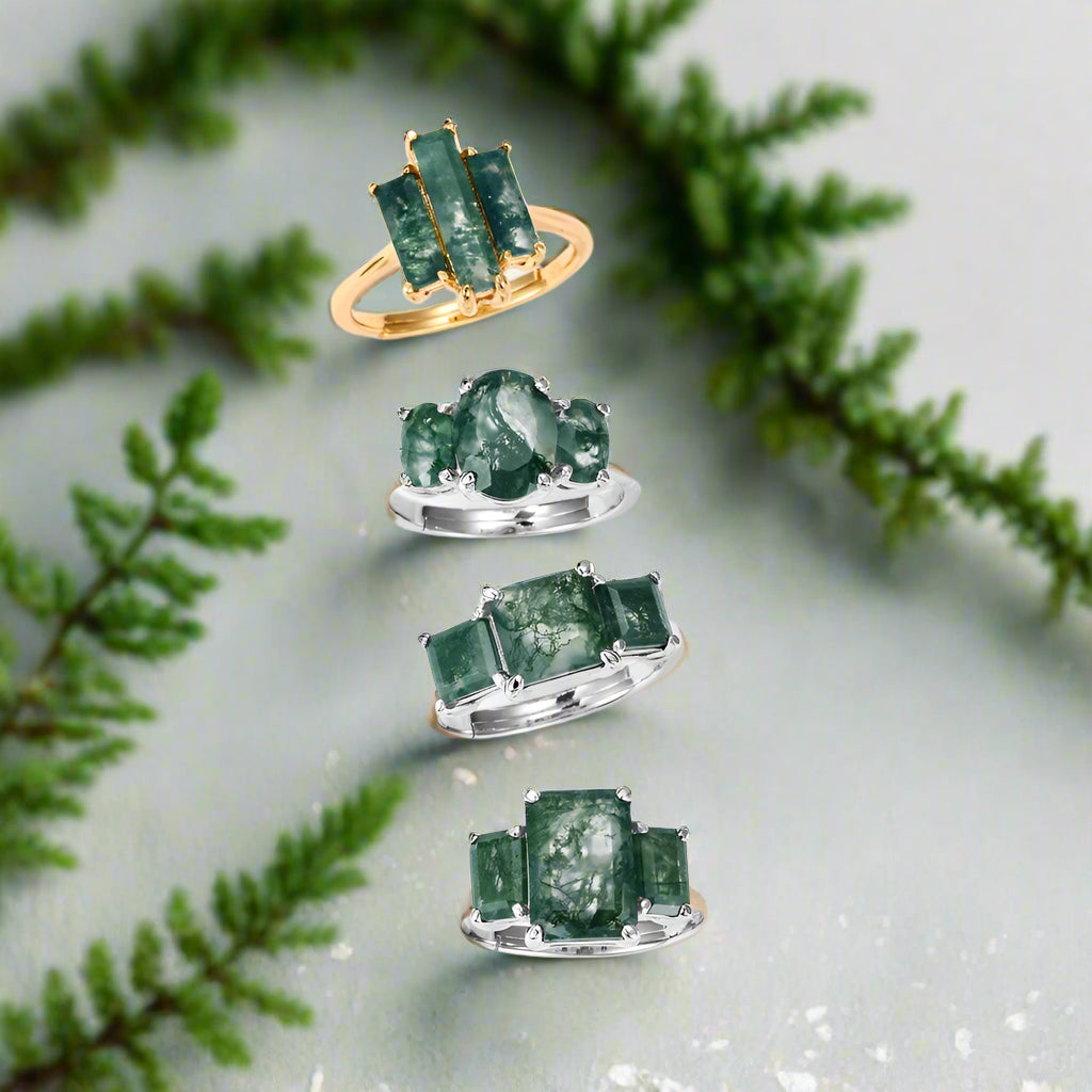 Set of green gemstone rings on a white background