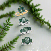 Set of green gemstone rings on a white background