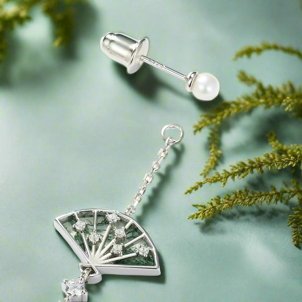Silver earring with fan-shaped pendant and chain on a white background