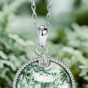 Silver necklace with a green pendant on a light blue background