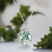 Silver pendant with a green stone on a white background