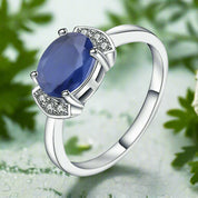 Silver ring with a blue gemstone and small diamonds on a white background