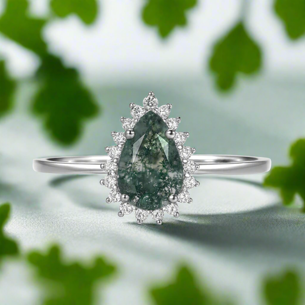 Silver ring with a green gemstone and diamond accents on a white background