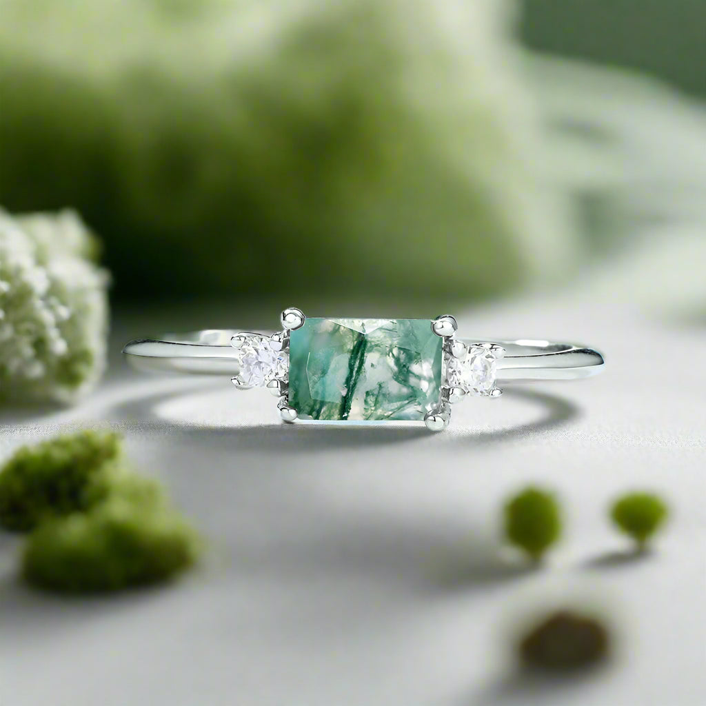 Silver ring with a green gemstone on a light blue background