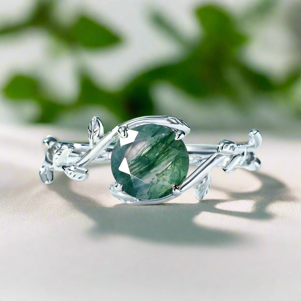 Silver ring with a green gemstone on a light blue background